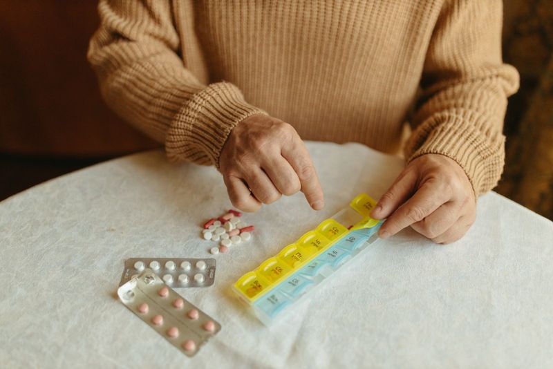 Un adulte prépare ses prises de la semaine dans un pilulier