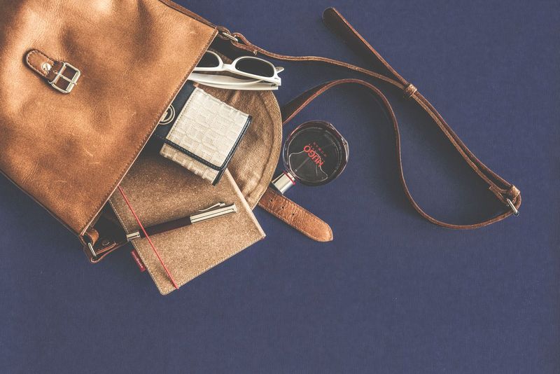 Le contenu d’un sac à main disposé à plat sur fond bleu